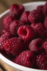 Fresh raspberries in a bowl on a wooden table
