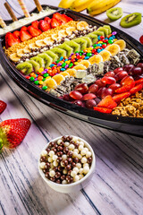 Acai frozen with banana, kiwi fruit, granola and candies for share. A boat for share.