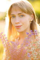 Portrait of beautiful blue eyed girl with lupin flowers 