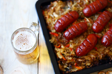 Selective focus. Macro. A glass of beer and sausages with sauerkraut. Oktoberfest theme. German beer with snacks.