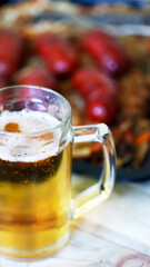 Selective focus. Macro. A glass of beer and sausages with sauerkraut. Oktoberfest theme. German beer with snacks.
