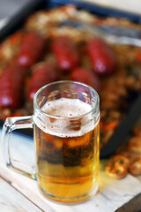 Selective focus. Macro. A glass of beer and sausages with sauerkraut. Oktoberfest theme. German beer with snacks.