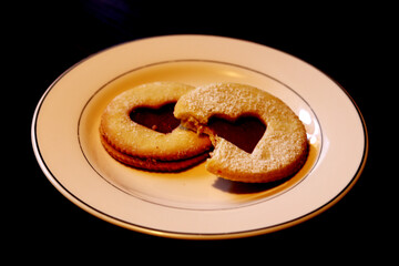 Traditional Linzer cookies with strawberry jam on a black background