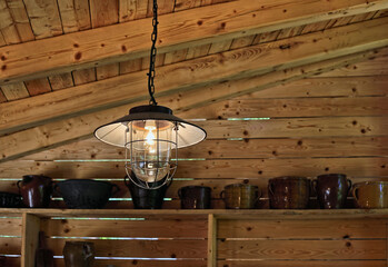 Vintage style lamp hanging inside a wooden barn © Dinadesign