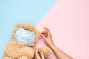 teddy bear in medical masks on a blue pink background, concept of protection from respiratory disease