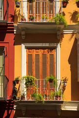 Malaga, Spain: colorful facade of houses with French windows at Plaza de la Merced