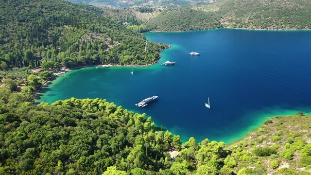 Aerial drone video of beautiful paradise bay and secluded beaches of Skinos covered in pine trees in beautiful Ionian island of Ithaki or Ithaca, Greece
