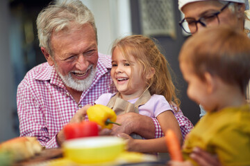grandparents having fun with their grandchildren in the kitchen