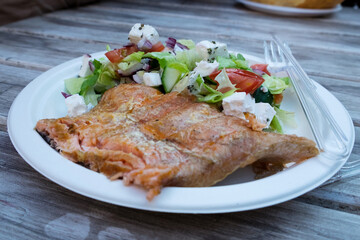 Delicious hungarian street food - smoked salmon fillets with greek salad