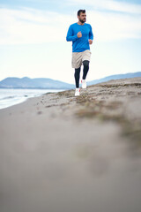 Young man jogging on the beach