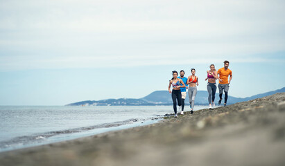 Group of young people running on the shore