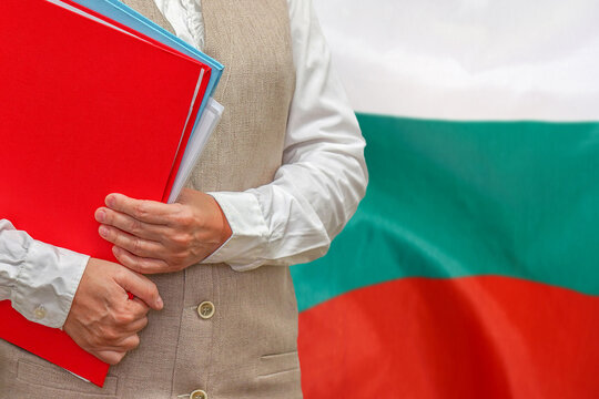 Woman holding red folder on Bulgaria flag background. Education and jurisprudence concept in Bulgaria