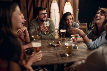 A man with a girls company having drink in the bar on the lake