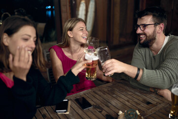 A man enjoying a toast with female friends in the bar on the lake