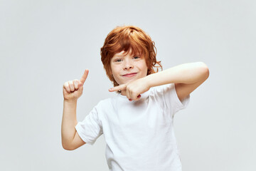 A cheerful boy shows his index fingers in different directions smiling Copy Space. © SHOTPRIME STUDIO