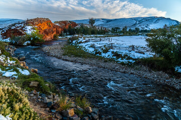 Red earth, rock formation is glowing in the setting sun along the Little Popo Agie River, Lander, Wyoming © Ron