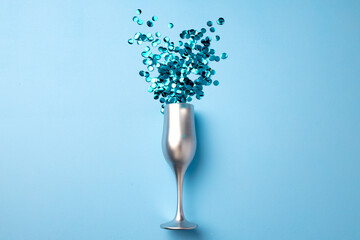 Champagne glass with confetti flat lay top view