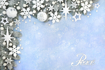 Christmas peace sign with snow covered fir border on pastel blue background with white star,...