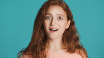 Naklejka premium Attractive excited girl amazedly looking in camera over colorful background. Wow expression