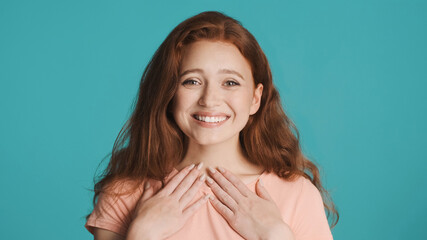 Fototapeta premium Pretty surprised girl joyfully looking in camera and smiling over colorful background. Excited expression