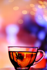 Transparent cup with tea on a colorful background. 
