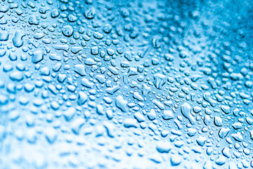 Rain drops on the window. Blue tone on the background. Many water drops on glass.