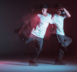 Stylish young guy breakdancer dancing hip-hop in neon light. Dance school poster. Long exposure shot