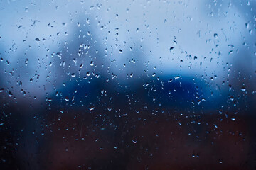 Drops on glass. There is a house on the background. Dark time of day. Brighter variant.