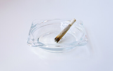 Rolling cigarette turned off in an ashtray. Smoking concept. Marijuana joint.