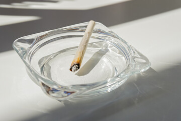 Rolling cigarette turned off in an ashtray. Smoking concept. Marijuana joint.