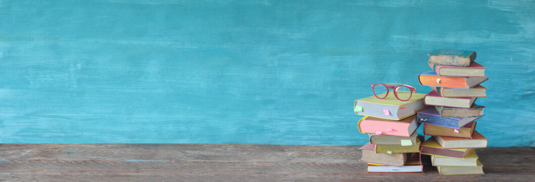 Stack of books and spectacles. Reading,literature,education,library,home office concept, panoramic large copy space