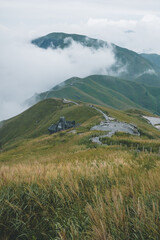Fototapeta premium Path winding on mountain ridge with landscape covered in clouds on Wugong Mountain in Jiangxi, China