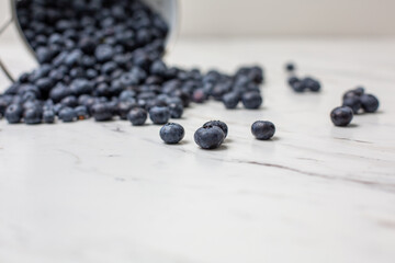 Overturned White Colander of Freshly Picked Blueberries on a White Countertop