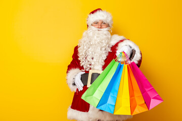 Santa Claus carrying bunch of colorful shopping bags