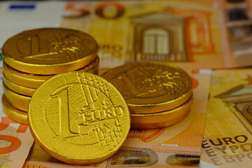 Euro closeup. Euro banknotes and golden 1 euro coins background.