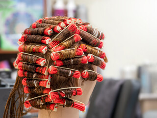 Perm training on a mannequin at the school of hairdressing - obrazy, fototapety, plakaty