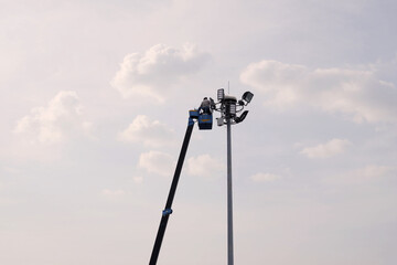 Workers equipped with helmets and safety equipment installed new diode lights. Workers in light...