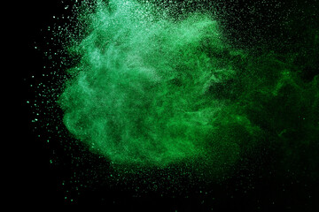 Green powder explosion on black background. Colored cloud. Colorful dust explode. Paint Holi.