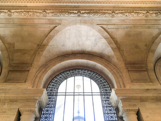 Hall or hallway in public building with marble columns and archs or archways, old lamps and ceiling...