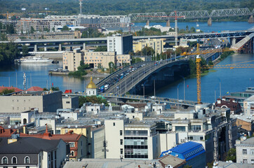 Urban view on Podilskiy district, Kyiv, Ukraine. Gavanskiy bridge across the Dnieper river, buildings, roofs and streets