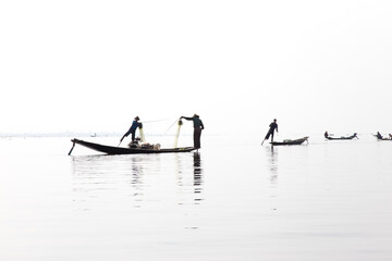 Naklejka premium Inle Lake, Myanmar 12/16/2015 traditional Intha fisherman rowing with one leg