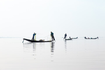 Naklejka premium Inle Lake, Myanmar 12/16/2015 traditional Intha fisherman rowing with one leg