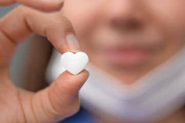 Naklejka premium Heart-shaped candy held by nurse.