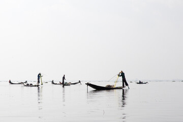 Naklejka premium Inle Lake, Myanmar 12/16/2015 traditional Intha fisherman rowing with one leg