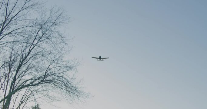 A small Piper aircraft flies over at sunset.