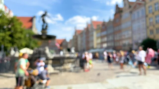 Blurry Scenery Of Gdansk Old Town With Tourists Taking Photos Of The Fountain Of Neptune In A Plaza - wide shot
