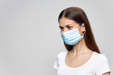 girl with a medical mask on her face looks towards Copy Space