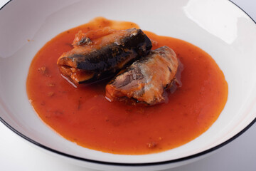 sardines in tomato sauce in a white plate on a white background