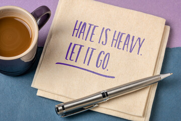 Hate is heavy. Let it go. Inspirational note on a napkin with a cup of coffee. Emotions and personal development concept.