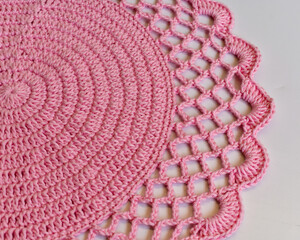Handmade crochet sousplat and white dishes.